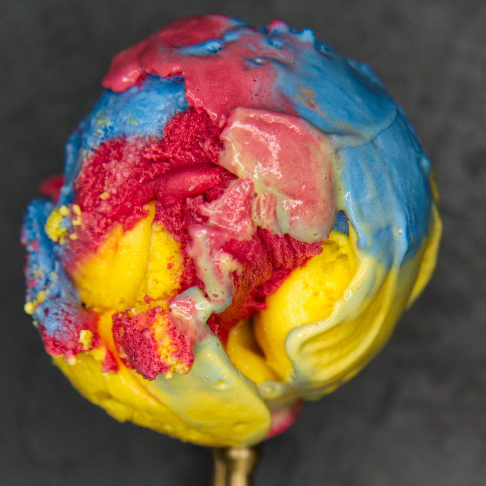 Scoop of red, yellow, and blue Superman ice cream at Wynston's