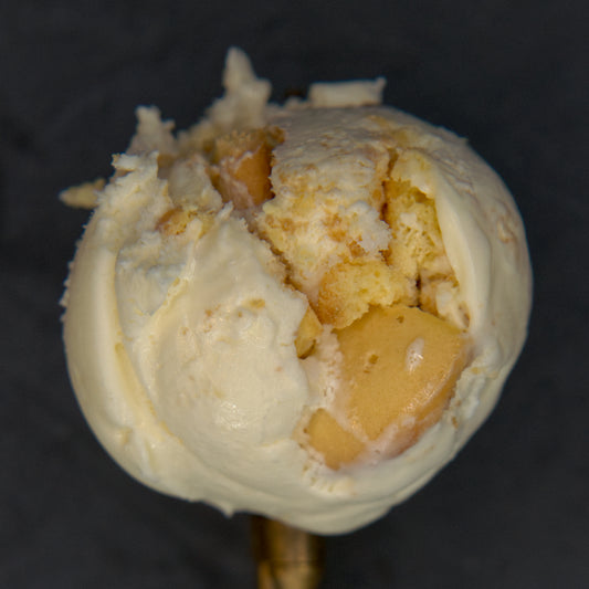 Close-up of a scoop of ice cream with cookie pieces on a dark background