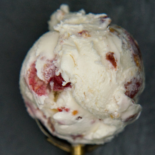Ice cream scoop with fruit pieces on a dark background