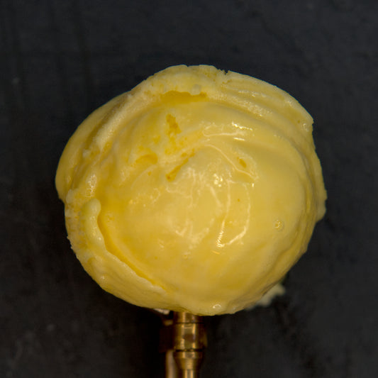 Yellow ice cream scoop on a dark background