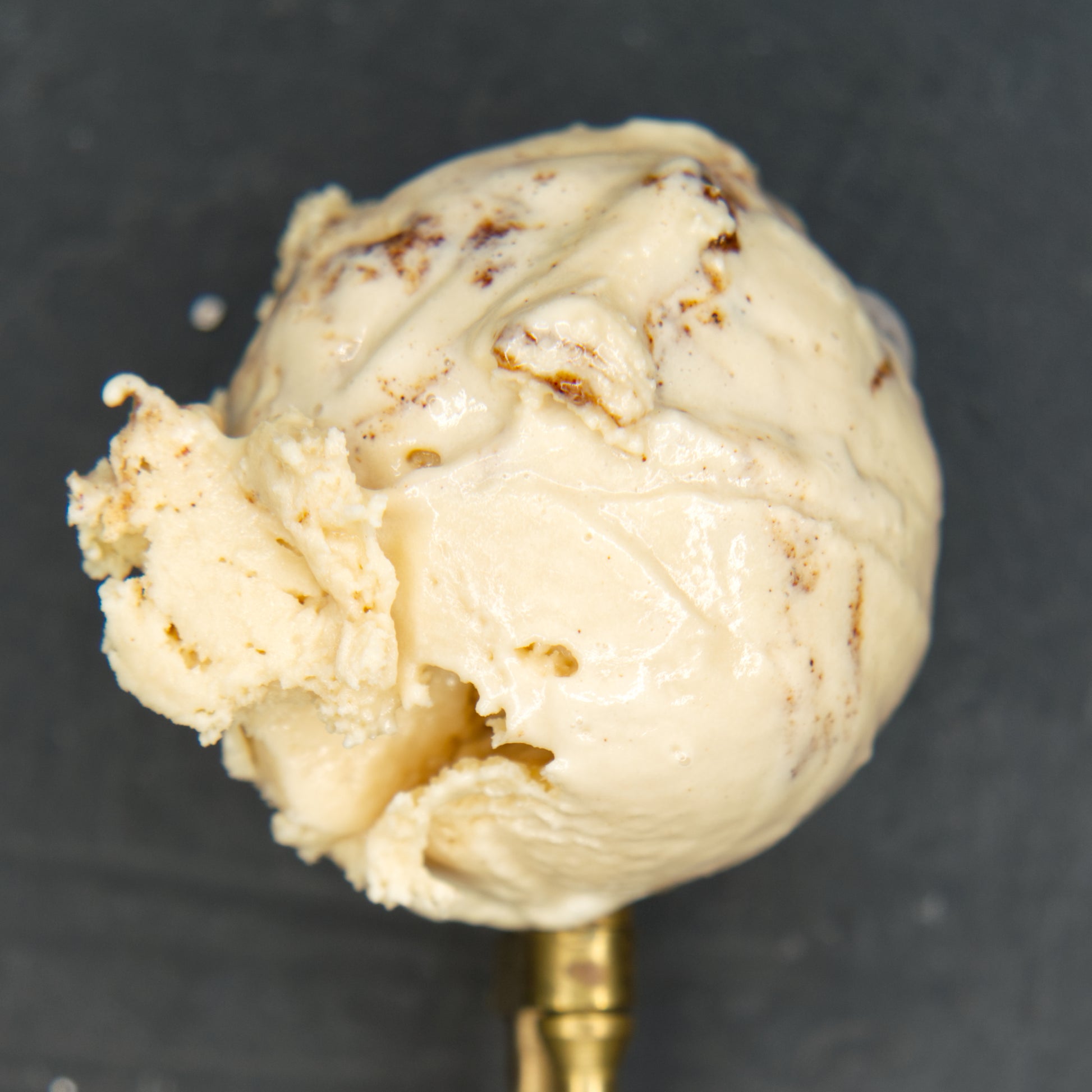 Ice cream scoop with ice cream on a dark background